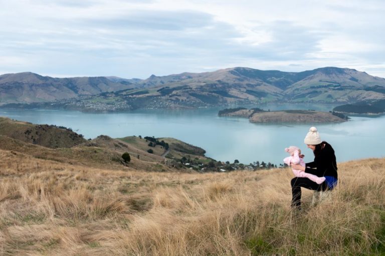 Jennifer from Backyard Travel Family spends quality time with baby Emilia, while overlooking Banks Peninsula from the Rapaki Track Walk, Christchurch, Canterbury