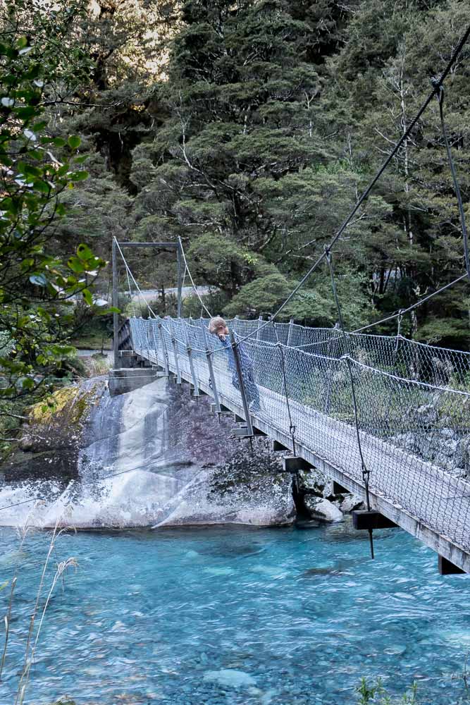 Nathan from Backyard Travel Family viewing the crystal clear water at the start of the Lake Marian Track. A great walk to the Marian Falls, crossing the swingbridge. A lovely short walk with kids