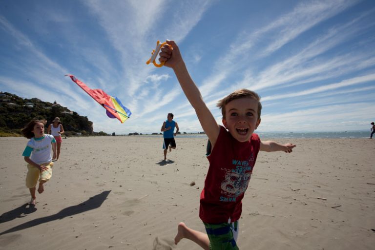 Kids flying kites at Sumner Beach, Christchurch. Photo by ChristchurchNZ