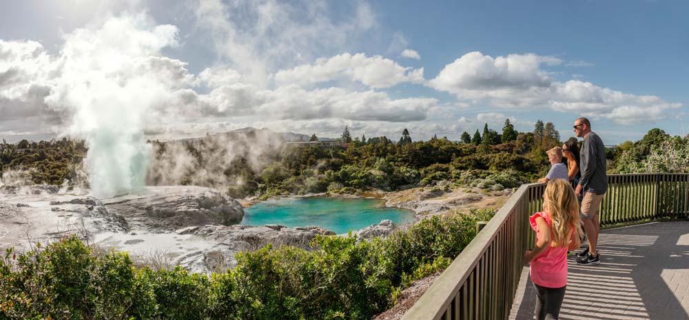 Family check out the geothermal activity and watch the geyser blow in Rotorua