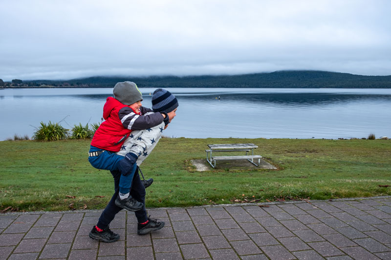 Nathan piggybacks Kipton on a Te Anau Walk along the lakefront