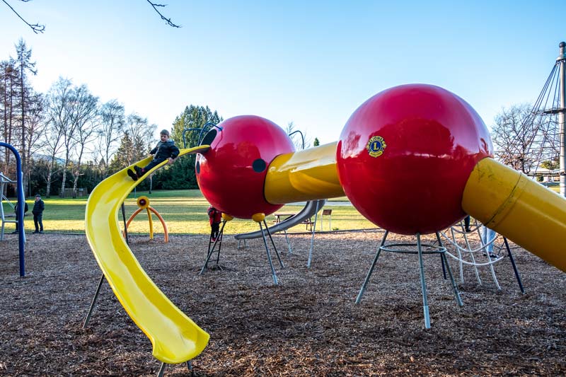 Nathan slides down a yellow slide at the Lions Park Playground in Te Anau: the best playground in Te Anau