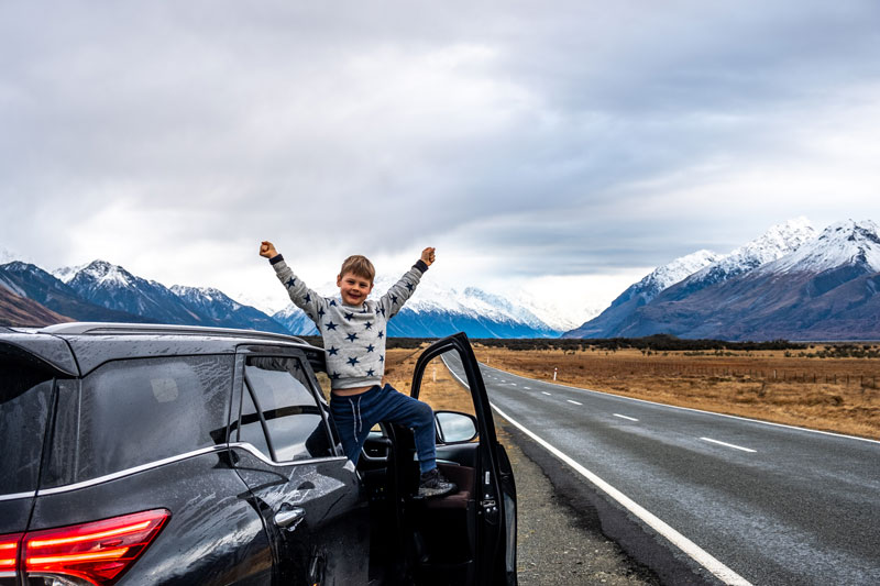 Nathan from Backyard Travel Family is pretty stoked to be on the Mt Cook Road, on the way to an epic Mt Cook hike