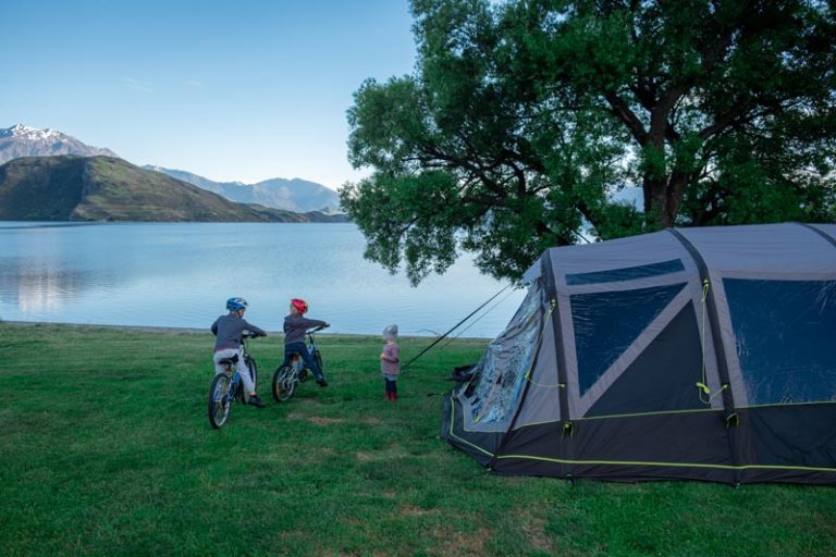 Family look over Lake Wanaka from their campsite at Glendhu Bay