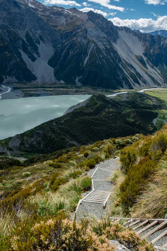 Looking down at the 2200 stairs on the Sealy Tarns Track, an uphill Mt Cook walk, with Mueller Lake in behind