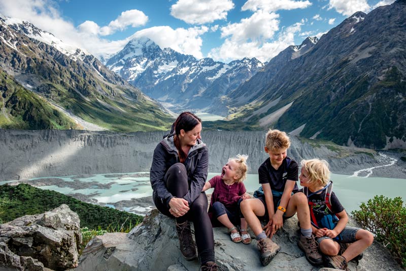 Backyard Travel Family sit at a viewpoint on the Sealy Tarns Track overlooking Mt Cook