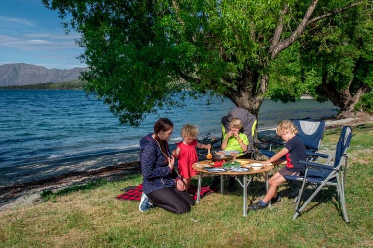 Backyard Travel Family make dinner beside Lake Wanaka while sitting at table and chairs