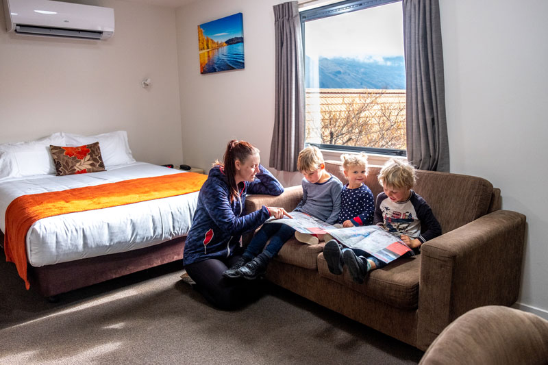 Family sitting reading a story in the Bella Vista Wanaka family accommodation