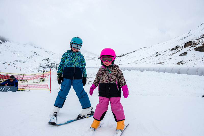 Emilia (3) and Nathan (7) ski together on the beginner slopes at the Remarkables Ski Area Queenstown