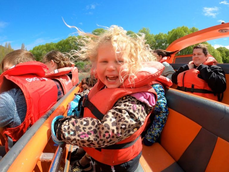 The best things to do in Queenstown with kids is Jet Boat with Go Orange. 3 year old Emilia squeals in delight as the jet boat zips down the Kawarau River, Queenstown, New Zealand