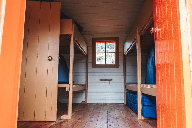 Bunk room inside the Hooker Hut. 6 beds with blue mattresses in this one room. A kitchen plus 2 more beds in the second room