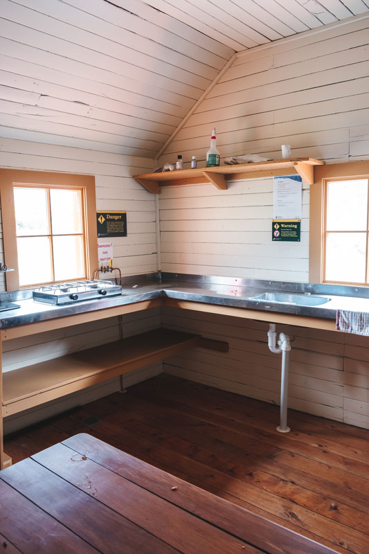 Kitchen at the Hooker Hut, complete with gas stove, sink and wooden dining table