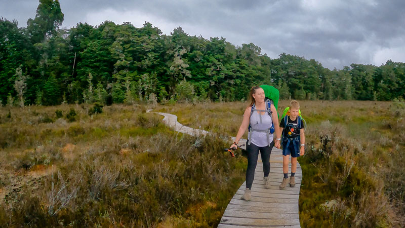 Jen and Nathan from Backyard Travel Family walk on a boardwalk in the marshlands section of the Kepler Track