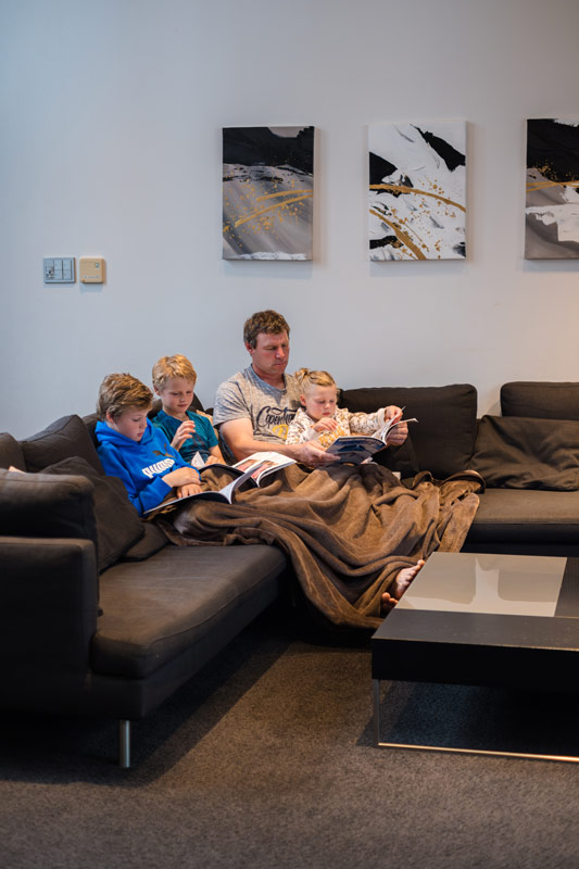 family relax on the couch of the Phoenix Chalets in Hakuba