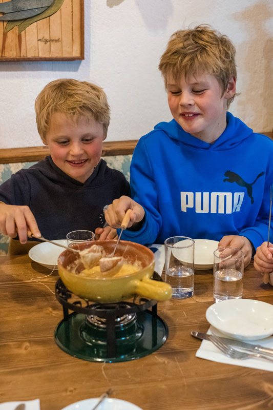 Kids dip their bread in the cheese fondu at Bernds Keller restaurant at the Marillen Hakuba ski resortr