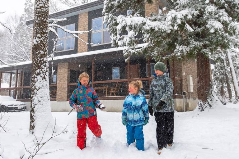 kids play in the snow in front of the Phoneix Chalets Hakuba accommodation