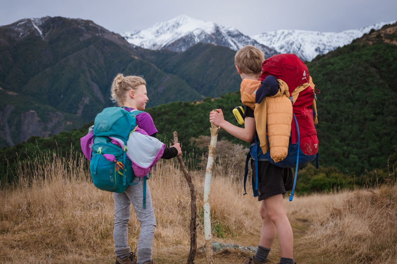 Emilia and Kipton from Backyard Travel Family have backpacks on their back for their overnight hike to Mt Fyffe Hut Kaikoura