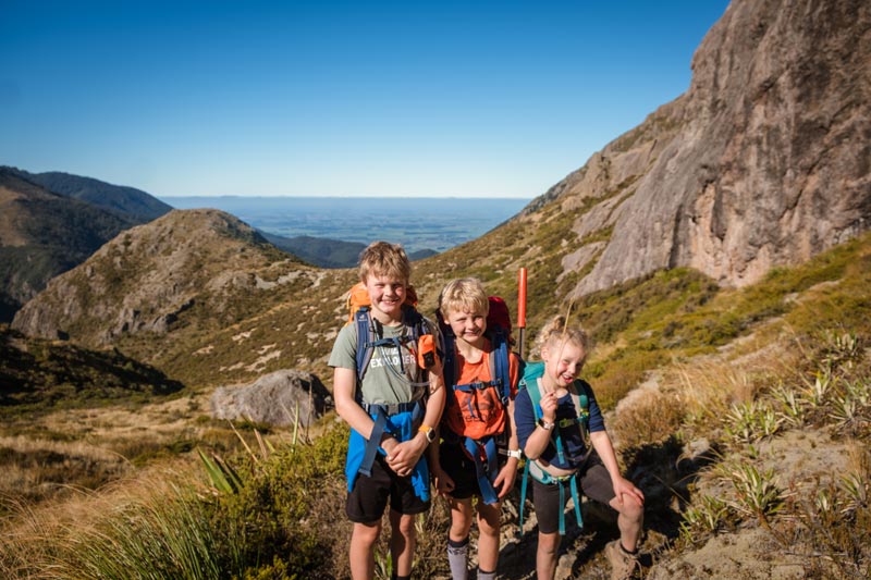 kids smile after climbing the hill behind Pinnacles Hut on the Mt Somers track