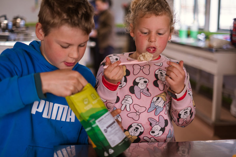 Kids eat back country cuisine freeze dried meals at a hut, which is a great tramping food idea