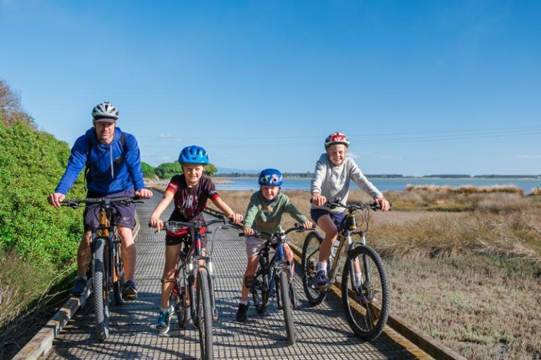 family with bikes on a boardwalk on the tasman great taste trail