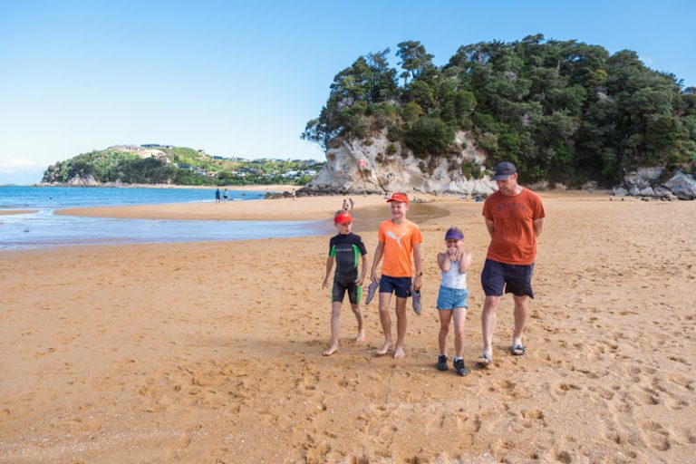 family walking on the golden kaiteriteri beach, where a section of the Tasman Great Taste Trail ends